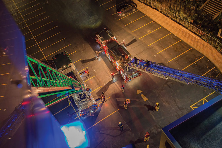 Two aerial fire trucks with ladders extended