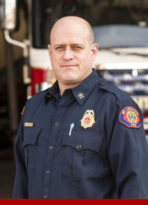 Deputy Chief of Operations and Safety Kurt Christofel standing in front of a fire engine