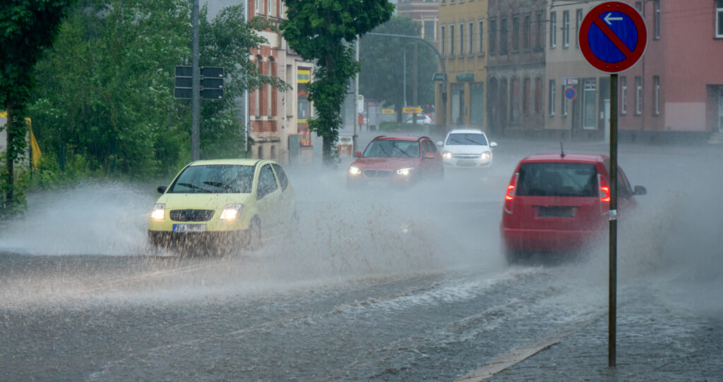 Cars driving in flooded road in the rain.