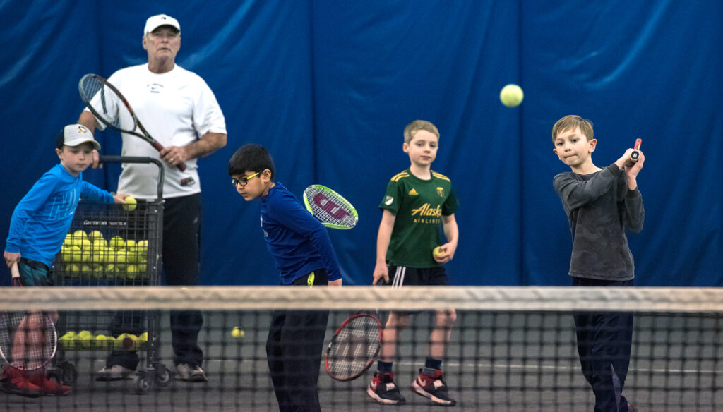 Tennis pro teaches children at the tennis center