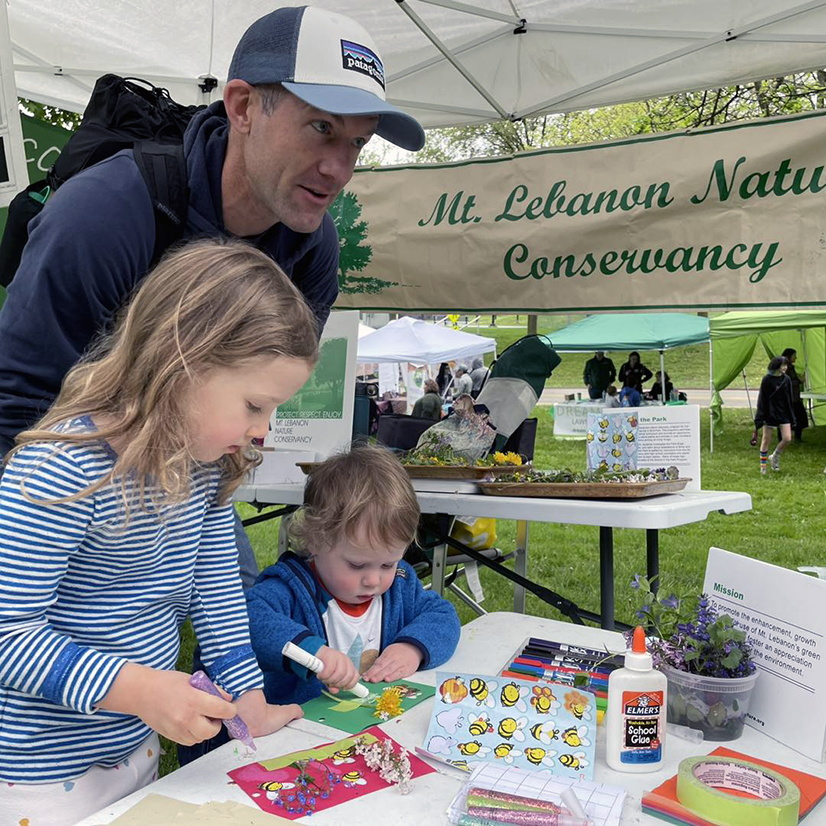Family working on crafts at the Nature Conservancy booth on Earth Day